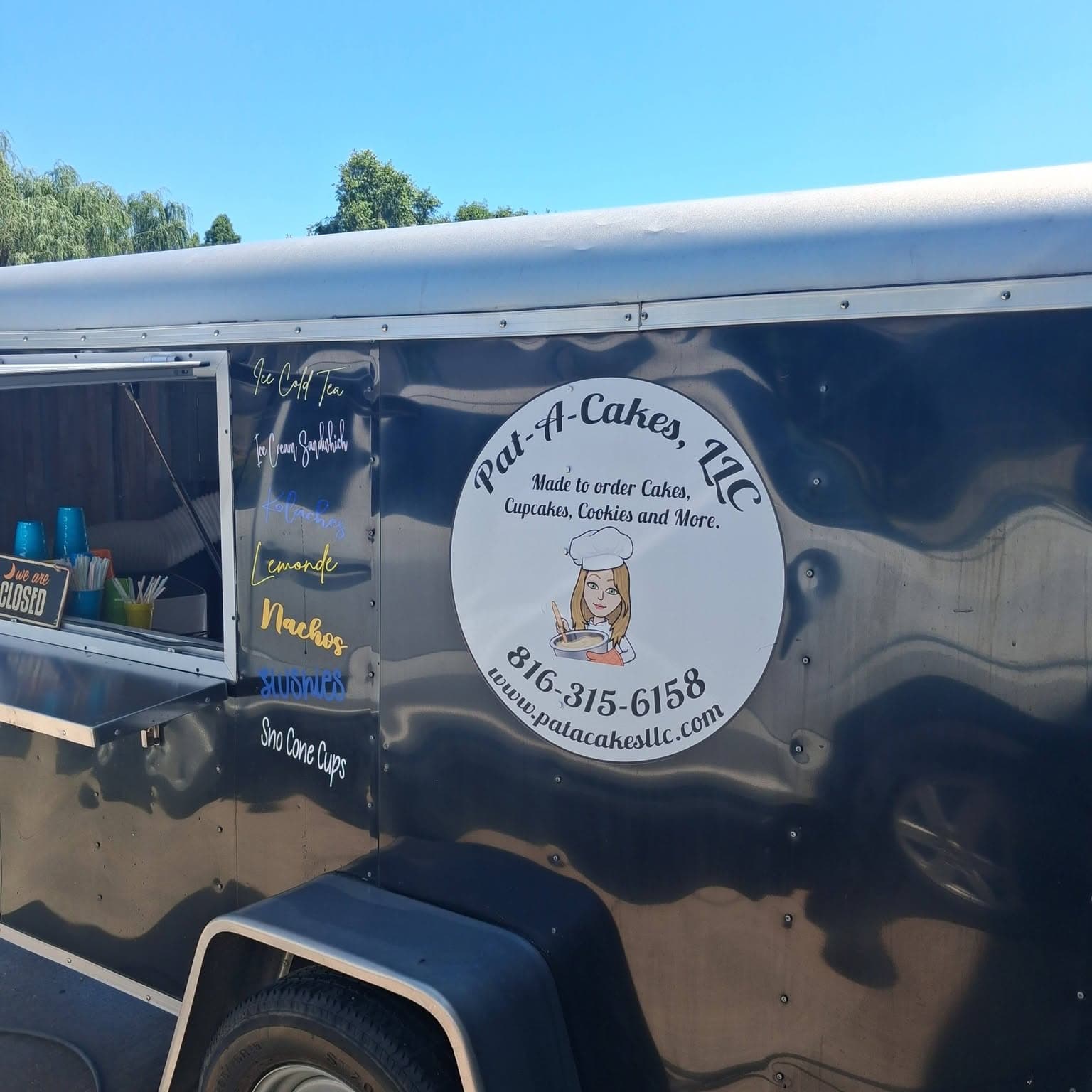 Side of the Pat-A-Cakes trailer listing tea, kolaches, lemonade, nachos and slushies